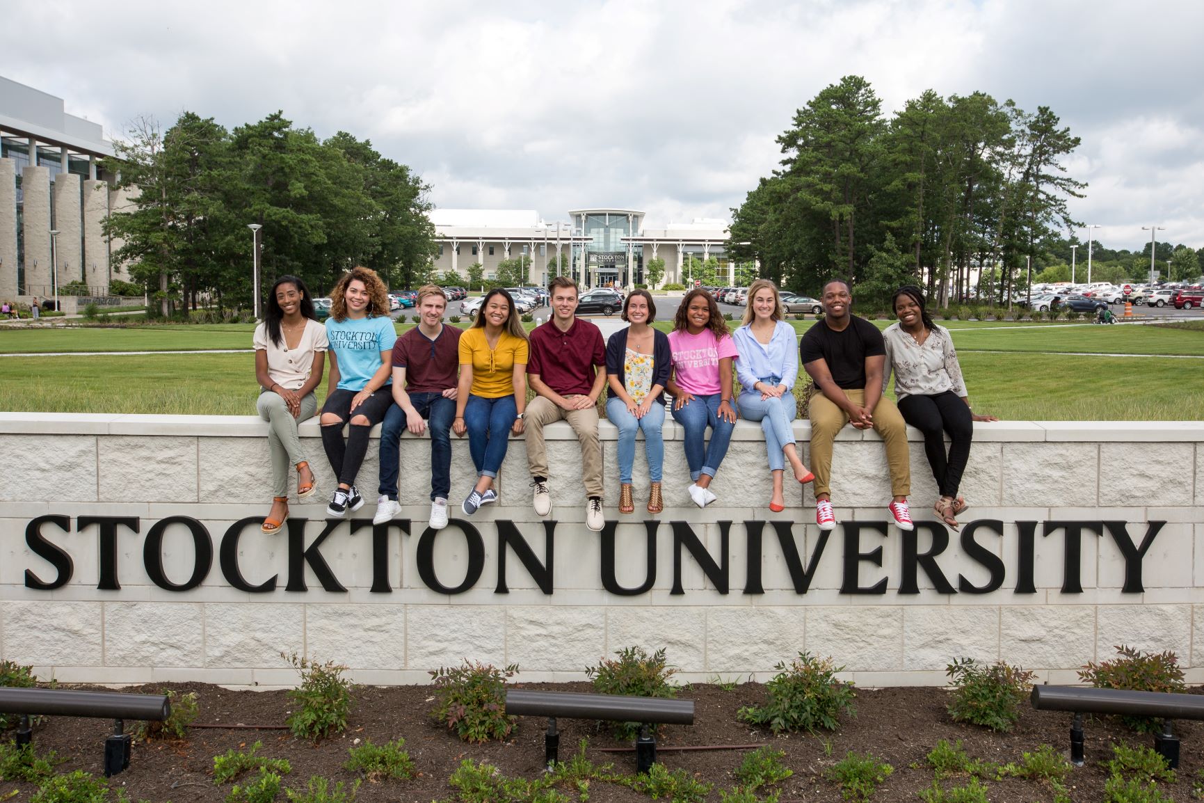students sitting outside on Stockton sign