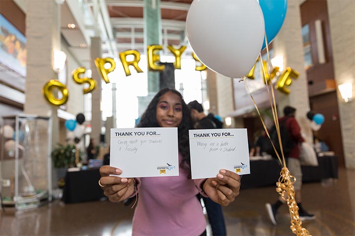 A student holds up thank you notes written for donors who gave during Ospreys Give