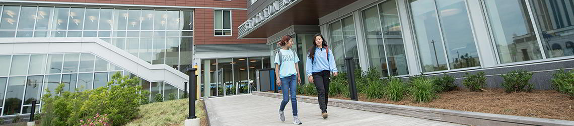 two students walking outside residential building