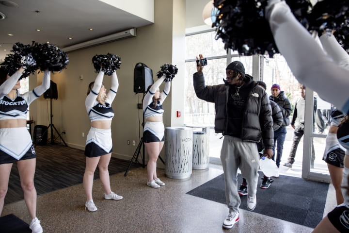 cheerleaders greet men's basketball players