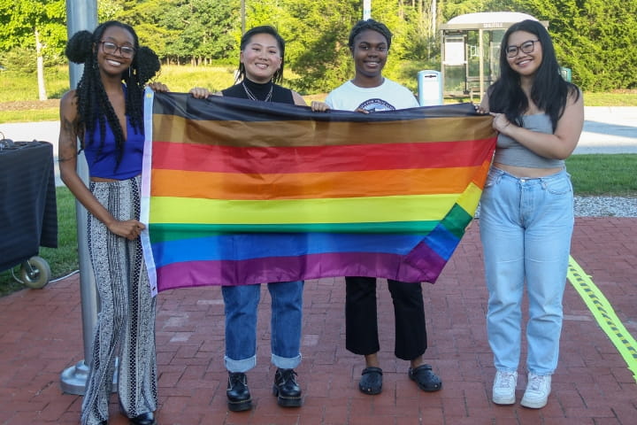 students holding flag at LGBTQ+ Flag Raising 