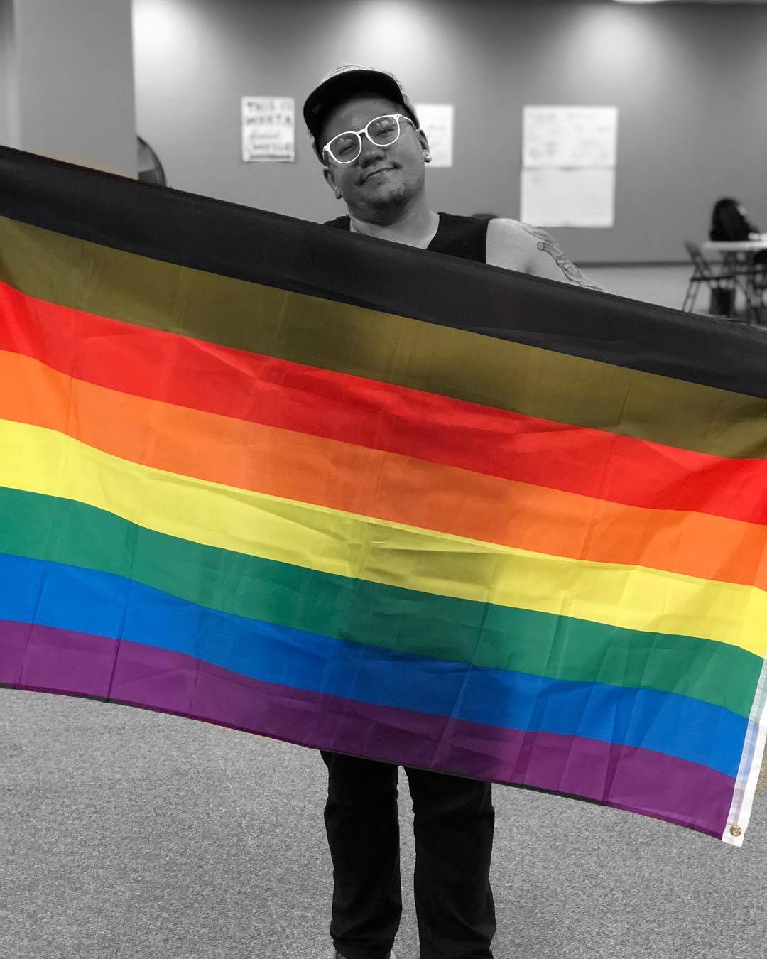 Eric Anglero holding a Pride flag