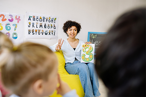 Stock image of a teacher in front of her class, provided by Pexels (Yan Krukau)