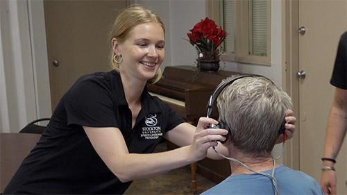 student aiding with hearing screenings