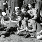 UNRRA 1944: A group of children read a Jewish newspaper as they await the train in Kaserne, Germany.