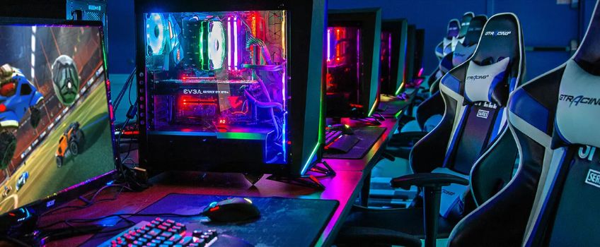 Stockton University Esports Lab Stockton University ESports Lab - gaming chairs facing computers with colorful neon mood lighting