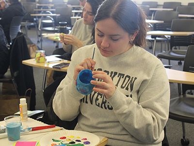 A student decorating a jar full of positive affirmations