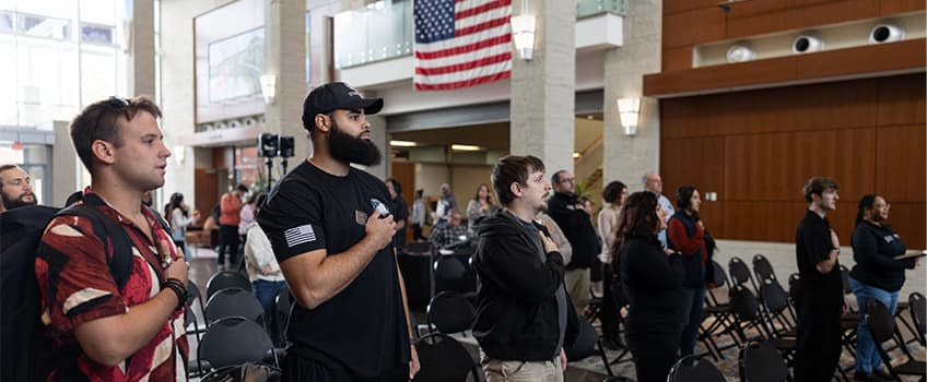 Stockton students salute the flag during a Veterans Day service on campus in 2025.