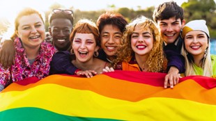 Young people carrying  a rainbow flag