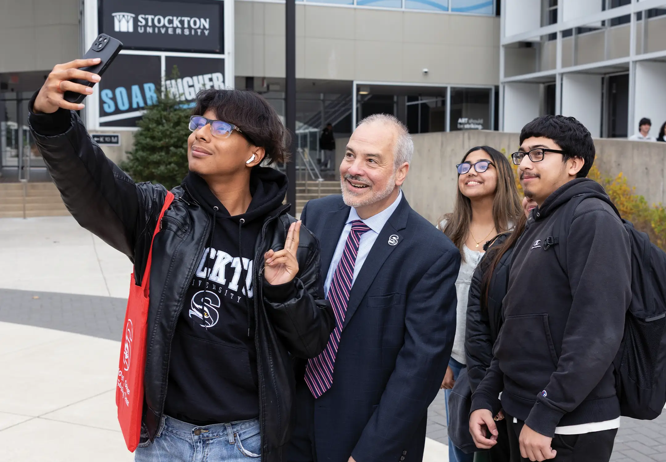 President Joe Bertolino takes a selfie with Stockton students, reflecting his commitment to building meaningful relationships across the campus community.