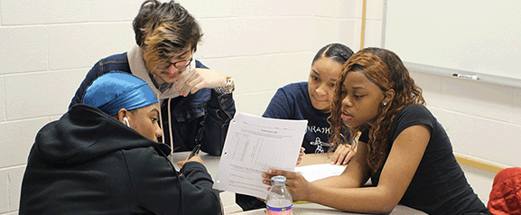 Egg Harbor Township High School students Wilson Batista, Christopher Butera, Destiny Brown and Isja'monee Banks work on a math project. Below, students Mary Gorman and Madyson Richardson (back to camera) talk with math teachers James DeBenedictis, left, and Matt Logan.