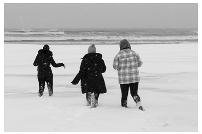 students on sand in snow storm