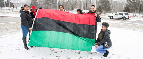 Students hold Pan-African flag outside in the snow