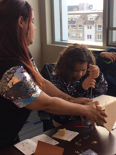 Ivette Santiago helps Yarianid Vasquez, 7, work on creating a birdhouse.