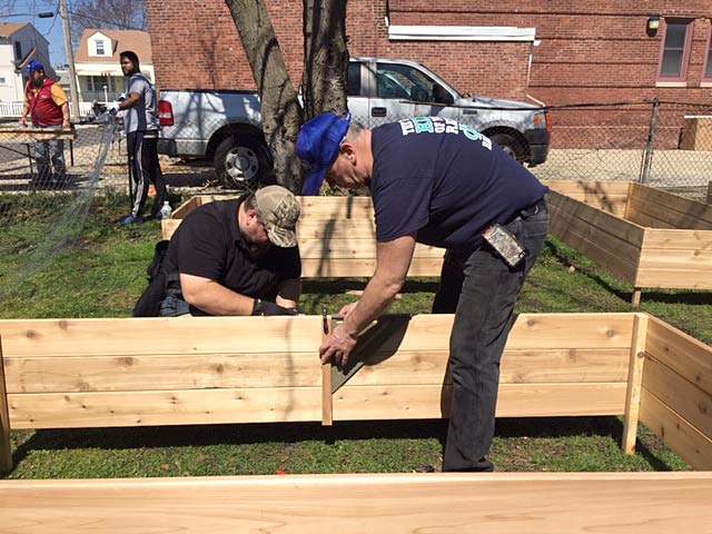 David Lockwood, left, works with an Atlantic City Fire Department member to build one of the eight beds for the community garden project in Atlantic City.