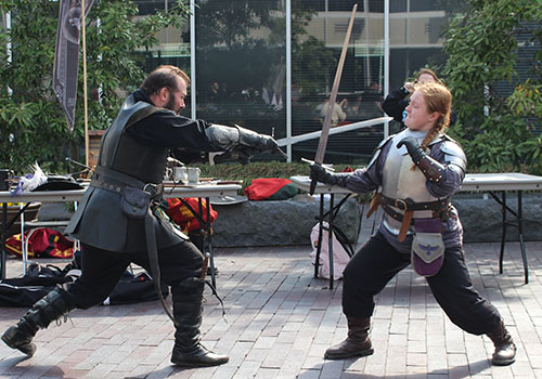 man sword fighting with woman
