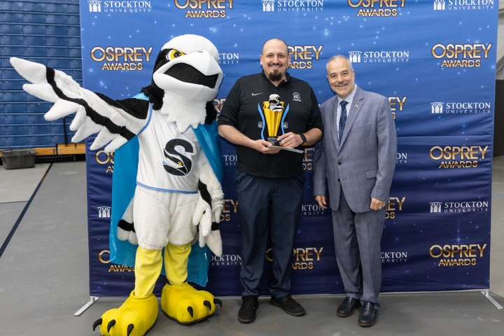 Stockton University mascot Talon, left, and President Joe Bertolino, right, greet Brian Pluchino, director of Residential Life