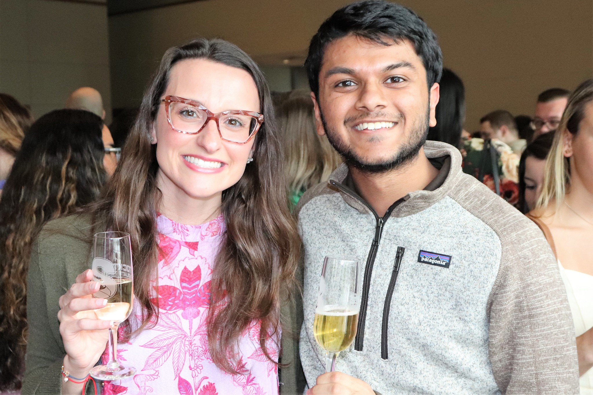 woman and man smiling with toasting glasses