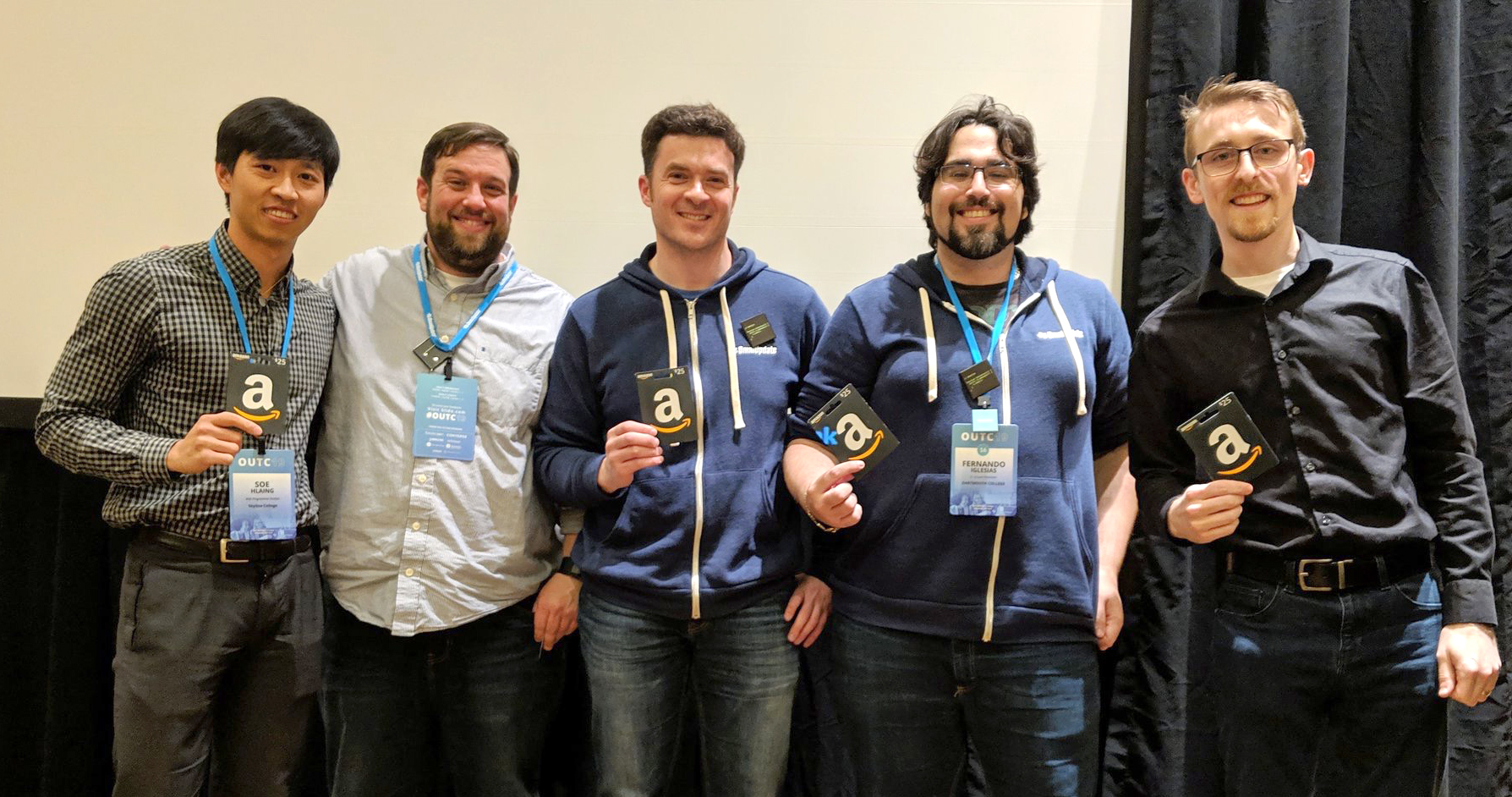 five men smiling holding gift cards