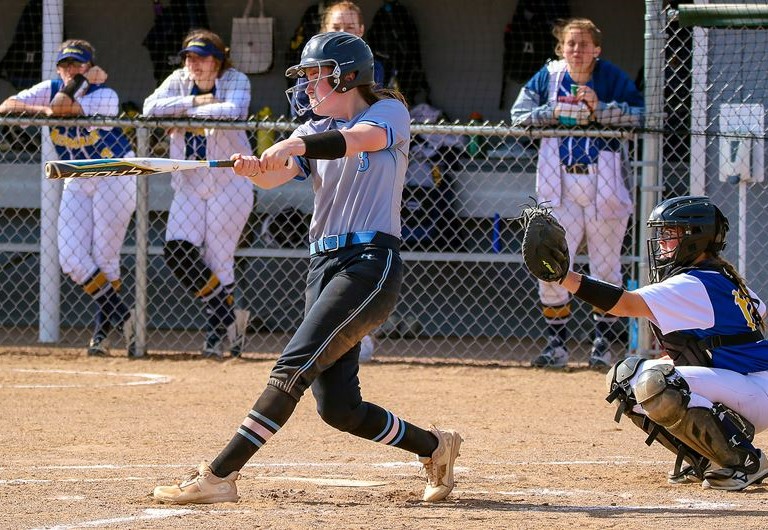 softball player hitting ball