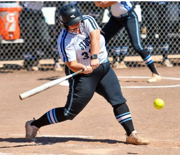 softball player swinging at ball