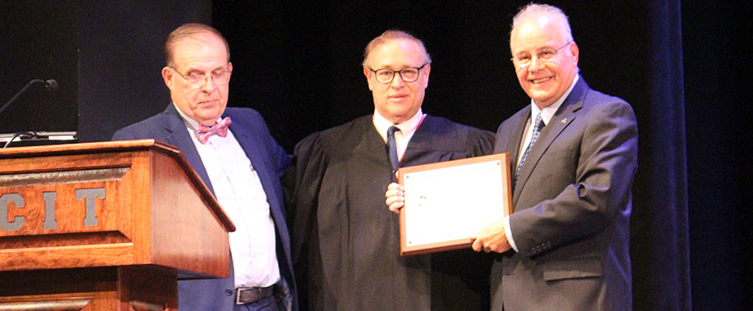 Assignment Judge Julio L Mendez and Recovery Court Judge Mark Sandson present Partner of the Year award to Stockton University President Harvey Kesselman