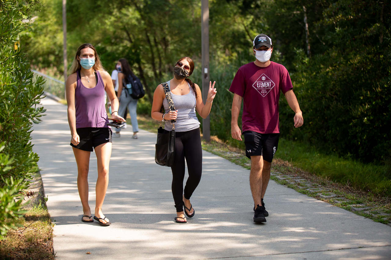 students wearing masks walking along path