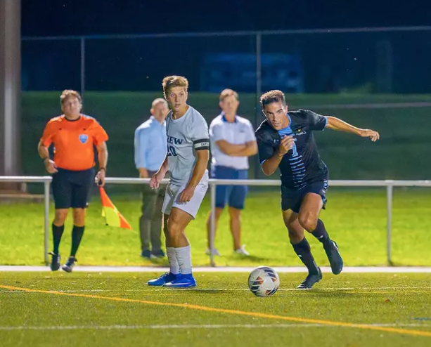 stockton mens soccer players on field with soccer ball