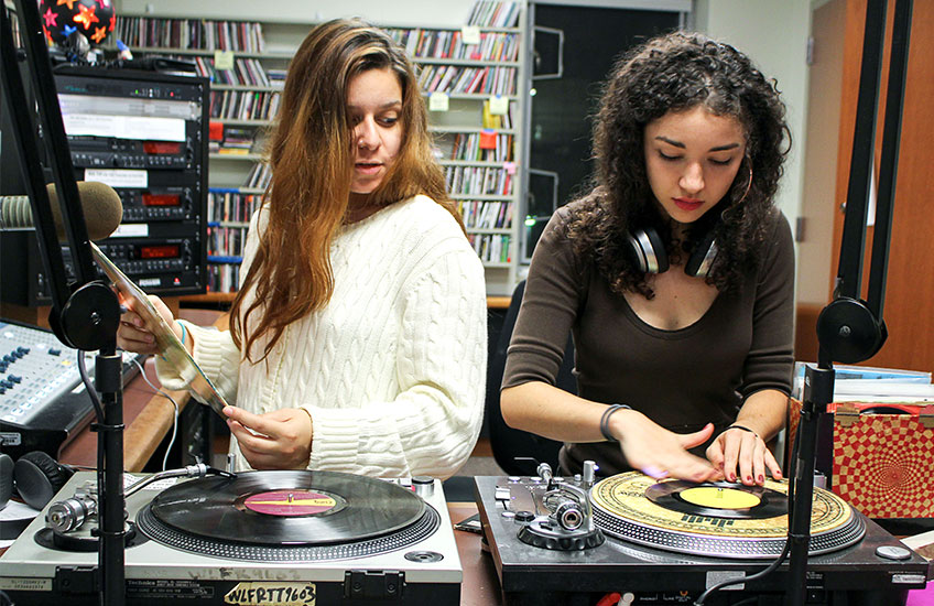 two girls working with DJ equipment 