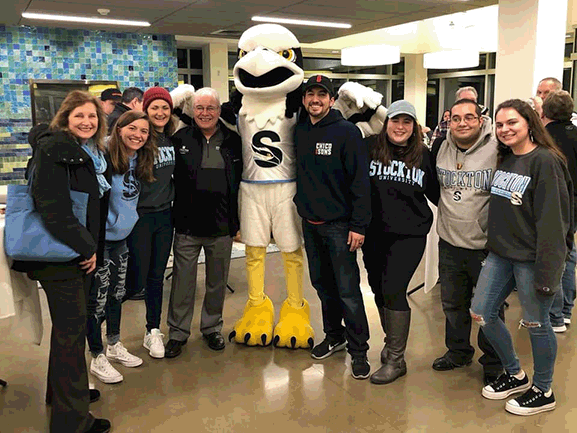 group of men and women standing with Osprey mascot 
