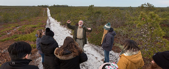 man talking to students on path outside