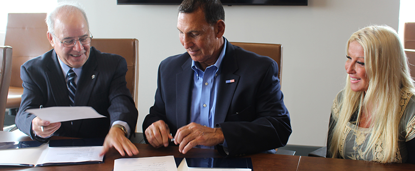 Harvey Kesselman and U.S. Representative Frank LoBiondo sign an agreement