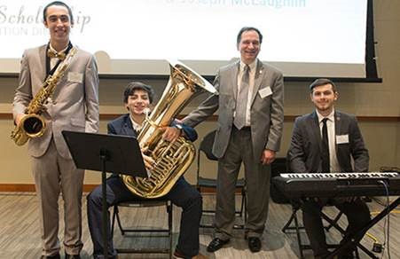 Instrumental music students and scholarship recipients Joseph McLaughlin, Robert Fell and Sebastian Bonilla with Associate Professor of Music Christopher DiSanto at the Scholarship Recognition Dinner.