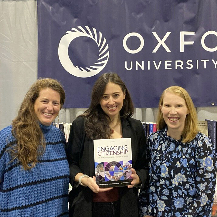 three faculty holding textbook