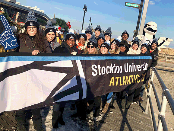 group of male and female students and staff with osprey mascot in parade