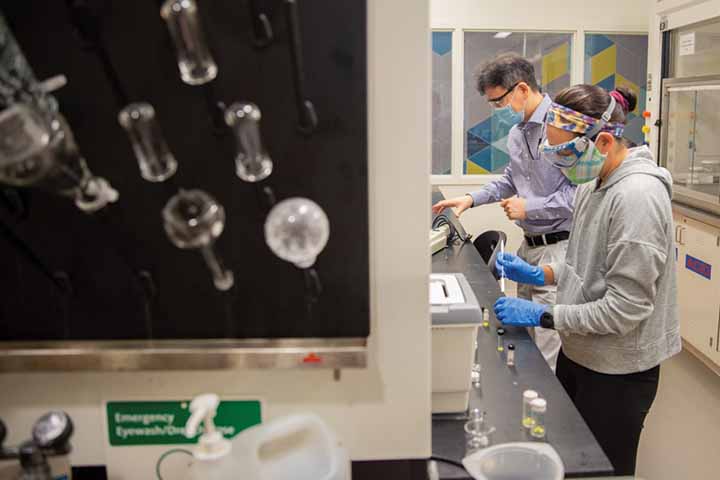 Daniel Ki and Kathleen Ngo wear face masks while working in a science lab