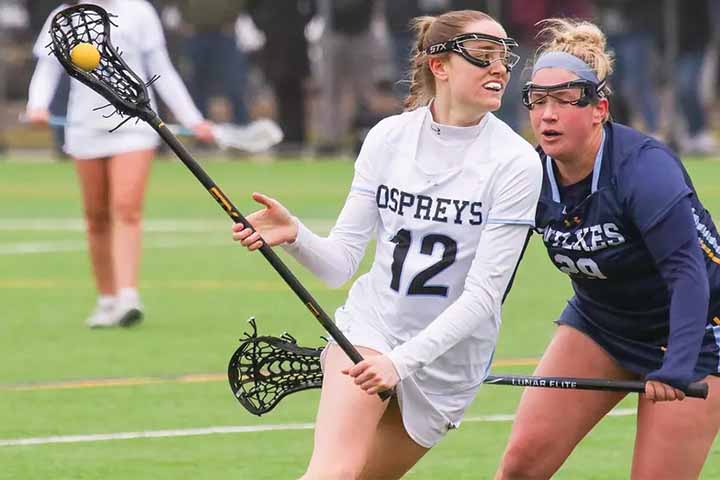 Brianna Robinson (#12) defends the lacrosse ball from an opponent