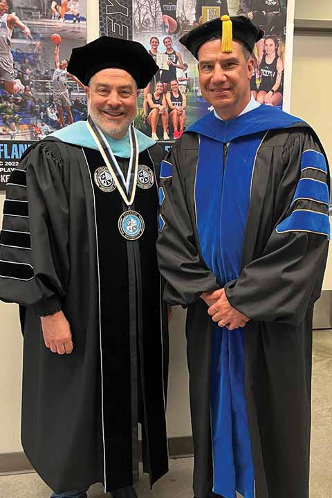 Joe Bertolino and Michael Palladino in commencement regalia in the Sports Center