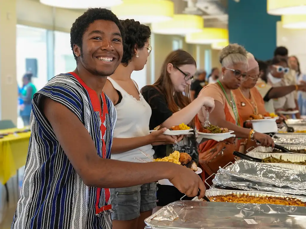 Stockton University student smiling at a celebration.